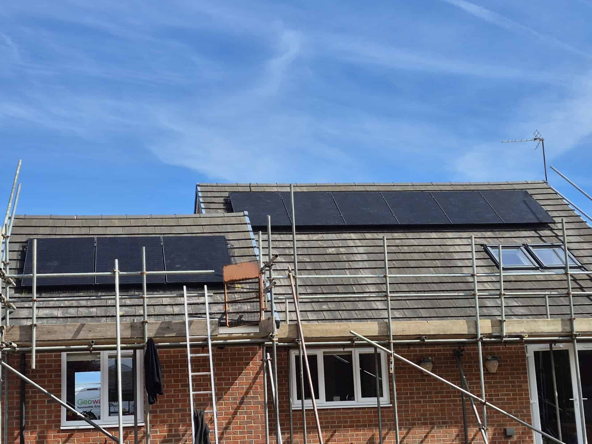 solar panels being installed on a red brick house