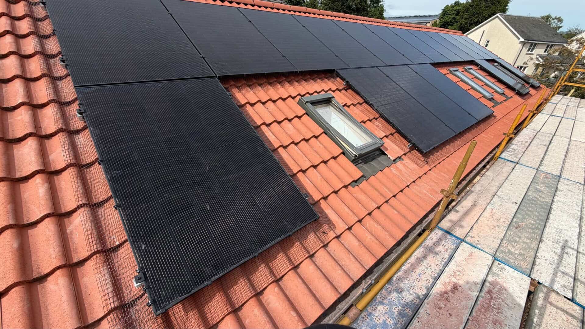 Completed solar panel installation fitted around rooflights on a pitched roof to maximise available roof space.