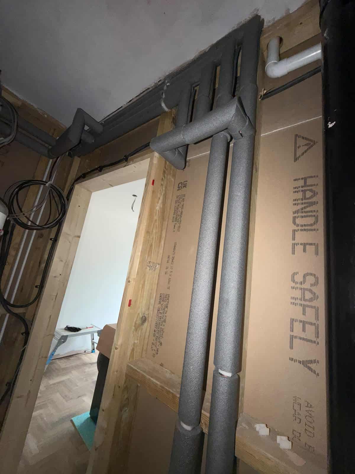 Insulated flow and return pipework forming part of the internal air source heat pump installation.